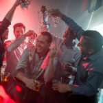 Happy group of men at a bachelor party at a nightclub having fun
